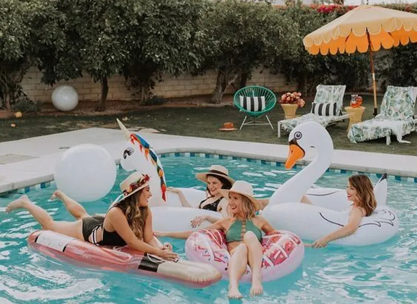 four womens on a buoy in a swimming pool