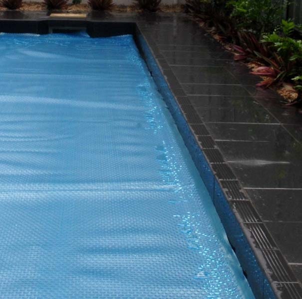 Ultra Silverback pool cover fitted over a dark-tiled swimming pool