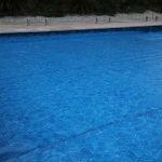 Ultra Watermark solar pool cover covering a large deep blue pool