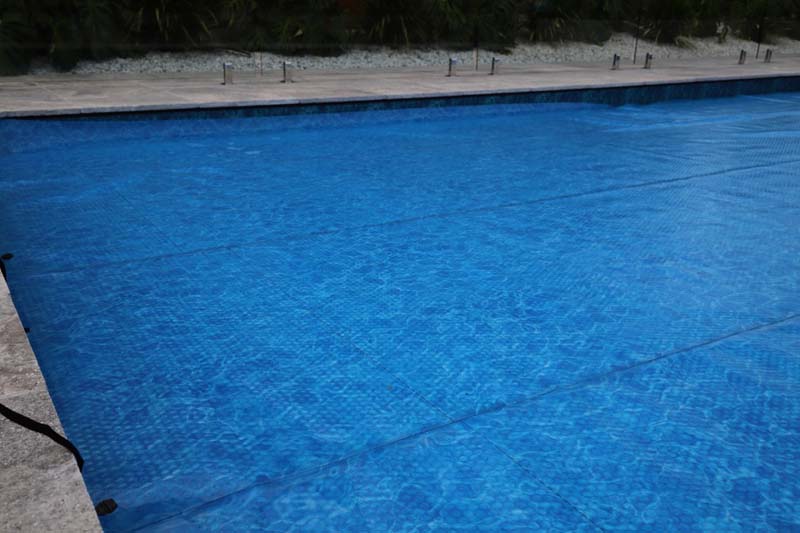 Ultra Watermark solar pool cover covering a large deep blue pool