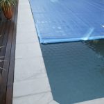 Ultra Thermal pool cover partially rolled back on a long lap pool