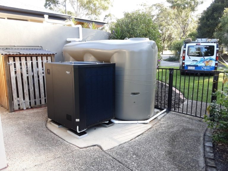 Pool heat pump installed next to a rainwater tank with a service van parked behind